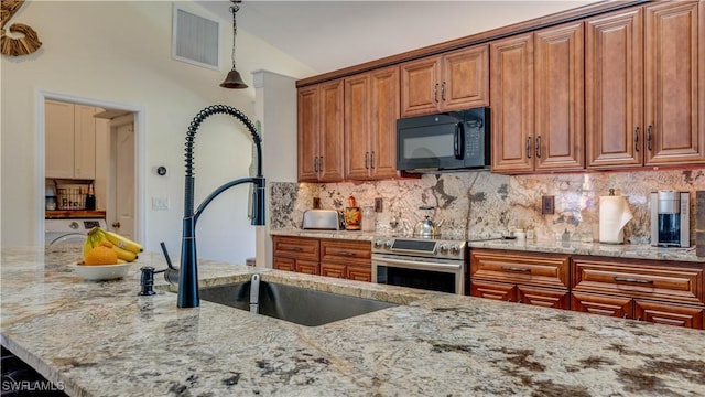 kitchen featuring visible vents, black microwave, light stone counters, brown cabinetry, and electric range