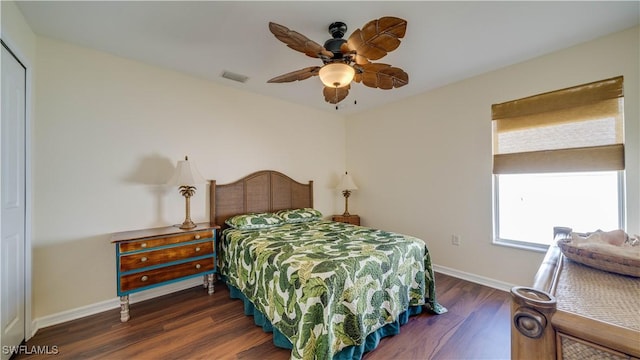 bedroom with visible vents, a ceiling fan, baseboards, and wood finished floors