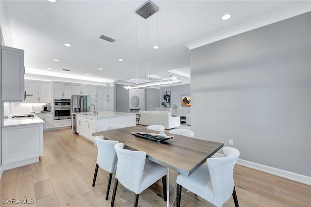 dining area with light wood-style flooring, recessed lighting, baseboards, and ornamental molding