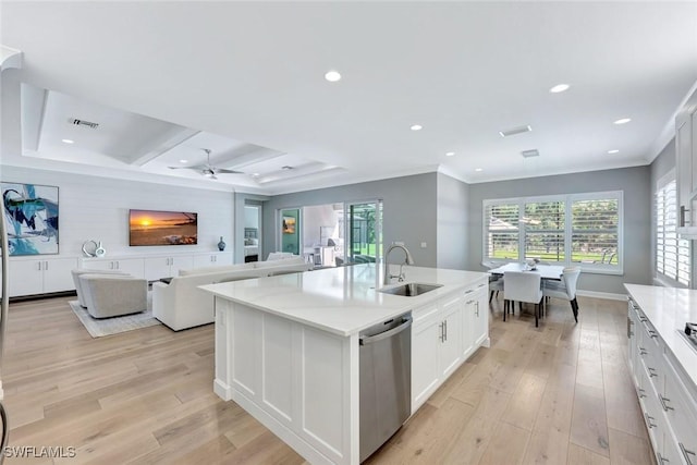 kitchen featuring a sink, dishwasher, a center island with sink, and light wood finished floors