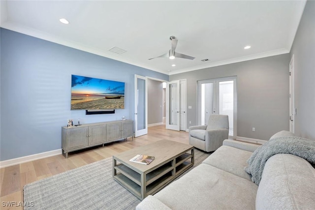 living room featuring french doors, light wood-type flooring, baseboards, and ornamental molding