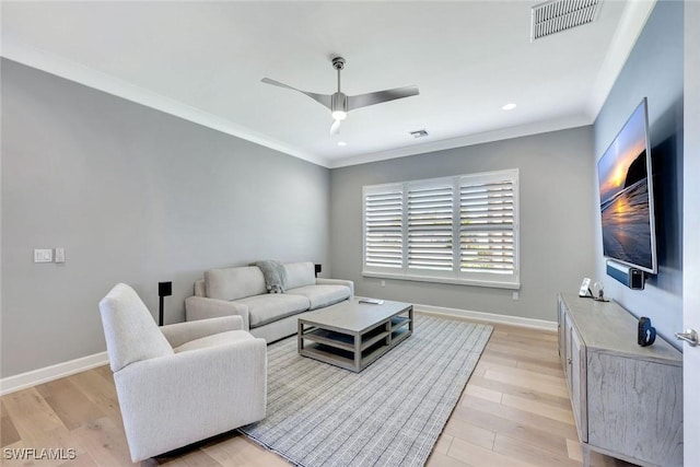 living area featuring crown molding, baseboards, visible vents, and light wood-type flooring