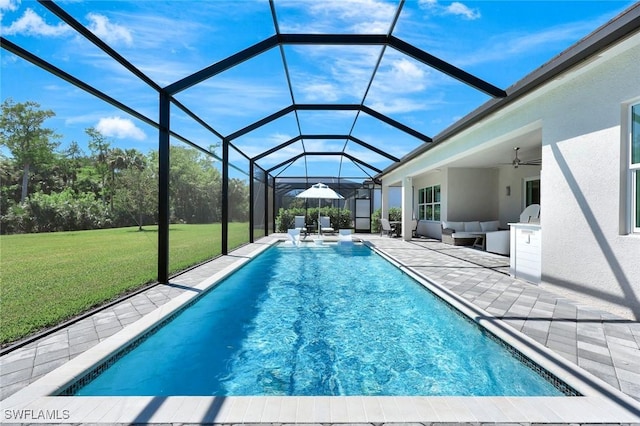 pool featuring a patio, a ceiling fan, a yard, outdoor lounge area, and a lanai