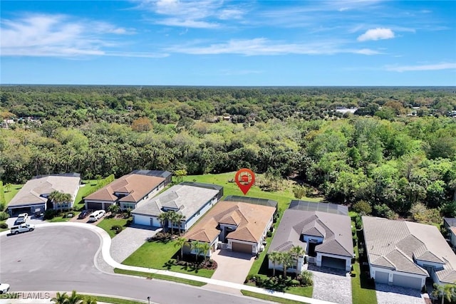 bird's eye view featuring a wooded view and a residential view