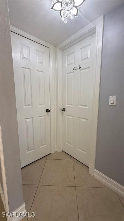 2510 SE 16th Pl Unit 103, Cape Coral, FL 33904 - doorway featuring a chandelier, light tile patterned floors, and baseboards