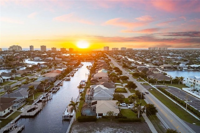 aerial view at dusk with a water view and a city view