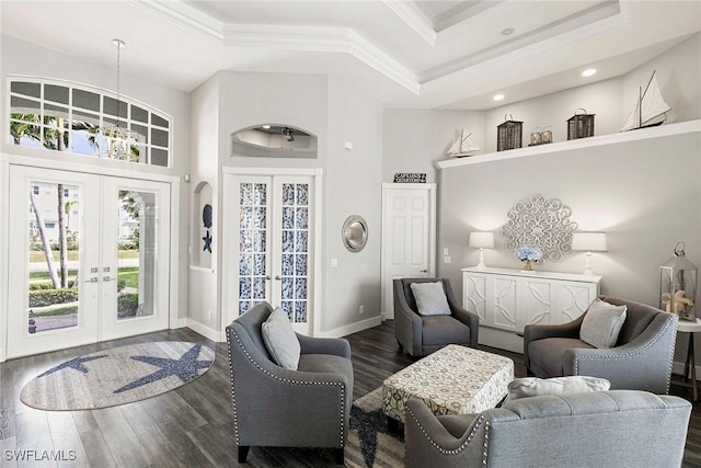 living room with dark wood finished floors, crown molding, french doors, and a raised ceiling