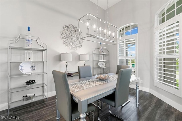 dining space with a chandelier, baseboards, and wood finished floors