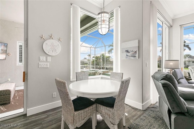 dining room with a sunroom, crown molding, baseboards, and dark wood-style flooring