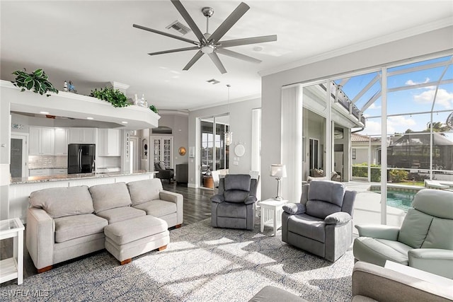 living room with visible vents, ceiling fan, light wood-style floors, and ornamental molding