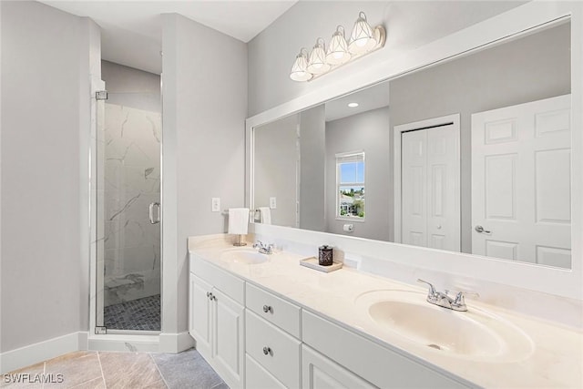 full bathroom with a marble finish shower, tile patterned flooring, baseboards, and a sink