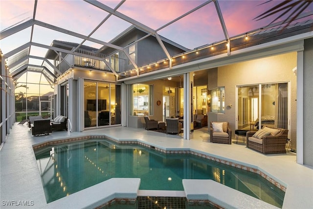 rear view of house with a patio area, stucco siding, an outdoor hangout area, and a pool with connected hot tub