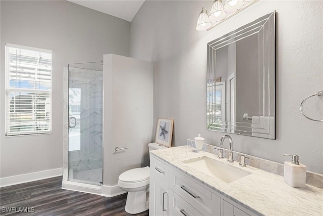 full bathroom with vanity, wood finished floors, baseboards, a marble finish shower, and toilet