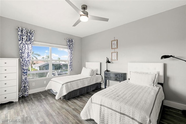 bedroom with a ceiling fan, baseboards, and wood finished floors