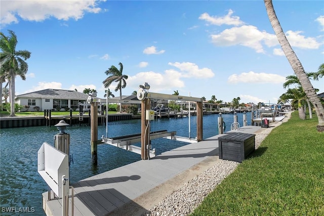 dock area with a lawn, a water view, and boat lift