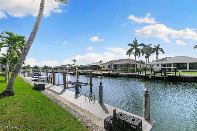 dock area with a yard, a residential view, a water view, and boat lift