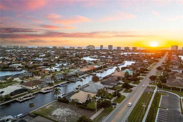 aerial view at dusk with a view of city and a water view