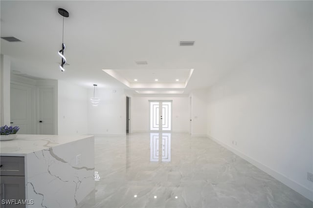 spare room with baseboards, visible vents, a raised ceiling, and marble finish floor