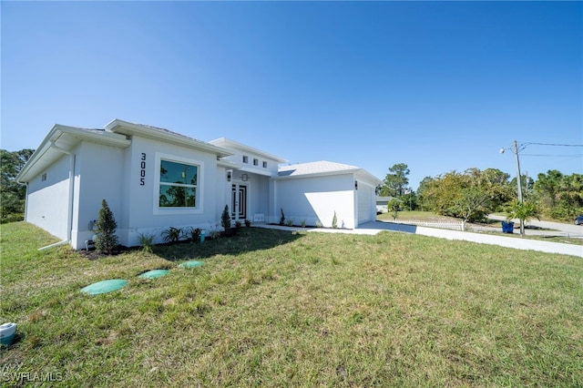 view of front of house with a front lawn, concrete driveway, and an attached garage