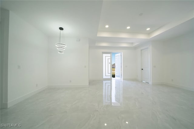 unfurnished room with recessed lighting, baseboards, a raised ceiling, and marble finish floor