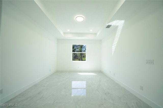 unfurnished room featuring baseboards, visible vents, recessed lighting, a raised ceiling, and marble finish floor