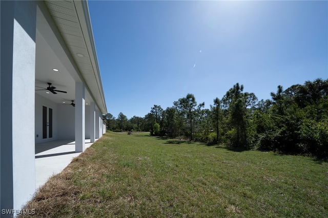 view of yard with a ceiling fan and french doors