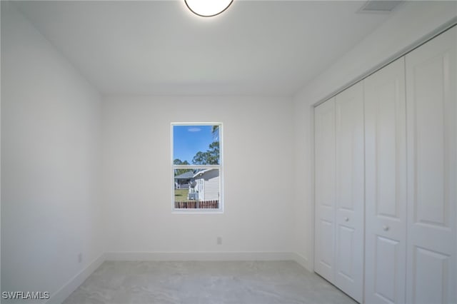 unfurnished bedroom with a closet and baseboards