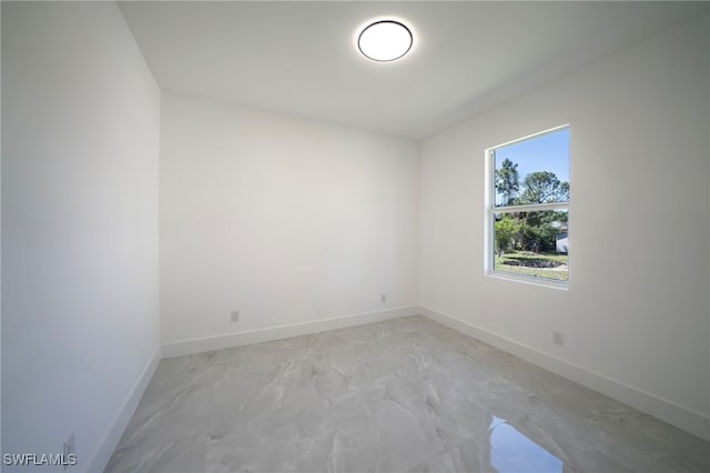 empty room featuring baseboards and marble finish floor