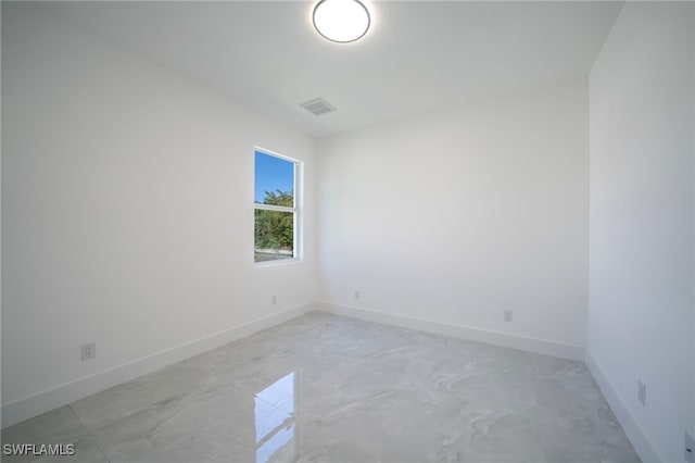 unfurnished room with visible vents, marble finish floor, and baseboards