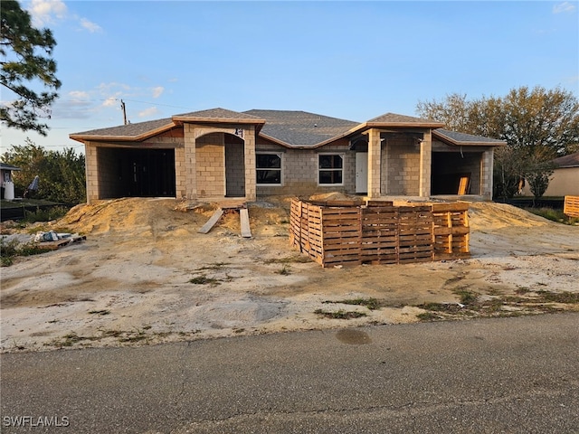 view of front facade featuring a garage, covered porch, and roof with shingles