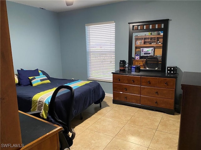 bedroom featuring light tile patterned floors, a ceiling fan, and baseboards