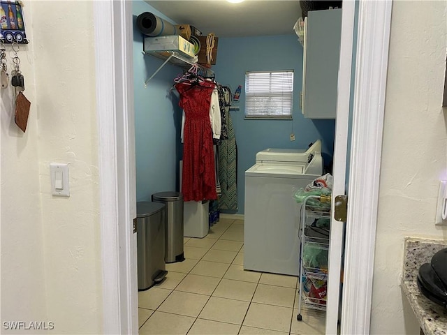 clothes washing area featuring washer and dryer, laundry area, and light tile patterned floors