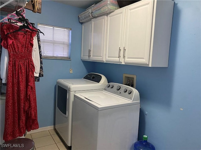 clothes washing area featuring light tile patterned floors, baseboards, cabinet space, and separate washer and dryer