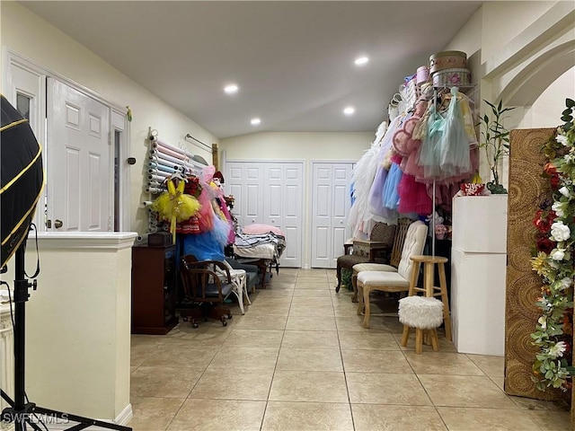 interior space with light tile patterned floors, recessed lighting, and lofted ceiling