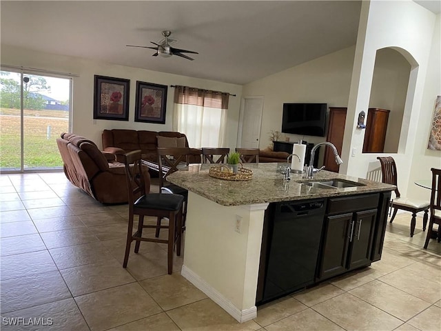 kitchen with open floor plan, dishwasher, an island with sink, light stone counters, and a sink