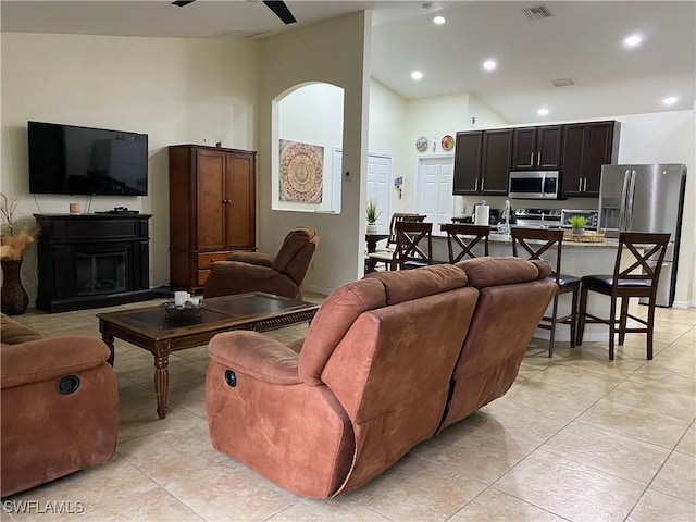 living room with visible vents, high vaulted ceiling, recessed lighting, arched walkways, and a fireplace