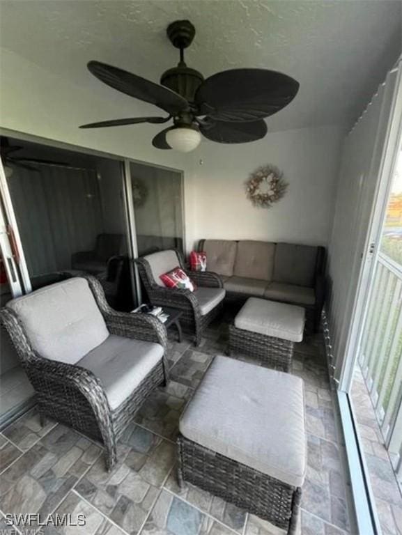 sunroom / solarium featuring a ceiling fan