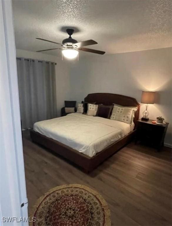 bedroom featuring ceiling fan, wood finished floors, and a textured ceiling