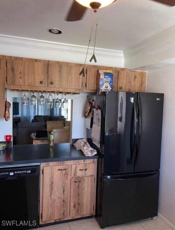 kitchen with black appliances, dark countertops, and brown cabinets