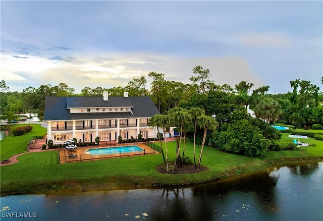 13189 Valewood Dr, Naples, FL 34119 - rear view of property featuring a balcony, a lawn, a patio, an outdoor pool, and a water view