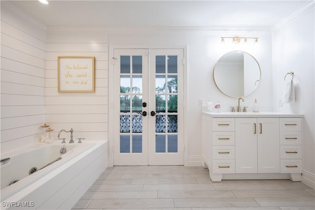 13189 Valewood Dr, Naples, FL 34119 - full bath featuring french doors, vanity, crown molding, a tub with jets, and wood finished floors