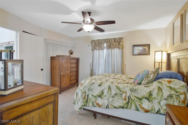 bedroom with light colored carpet and a ceiling fan