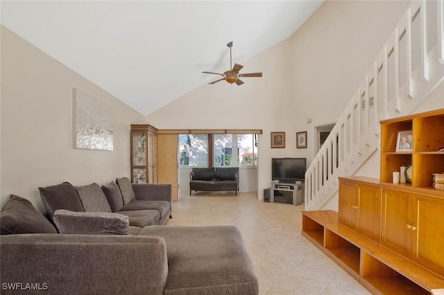 living area with high vaulted ceiling, stairs, and a ceiling fan