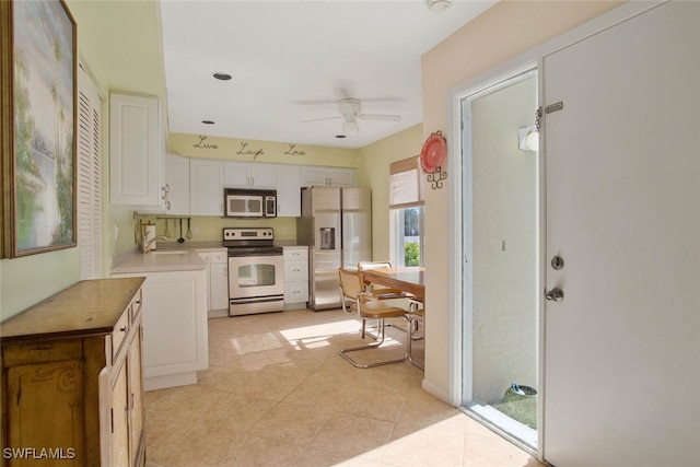 kitchen featuring a sink, ceiling fan, light countertops, appliances with stainless steel finishes, and white cabinetry