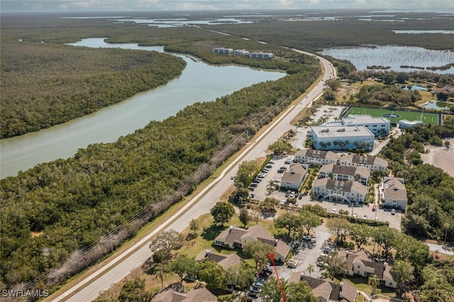 birds eye view of property with a wooded view and a water view