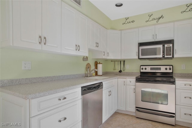 kitchen featuring a sink, light countertops, white cabinets, and stainless steel appliances