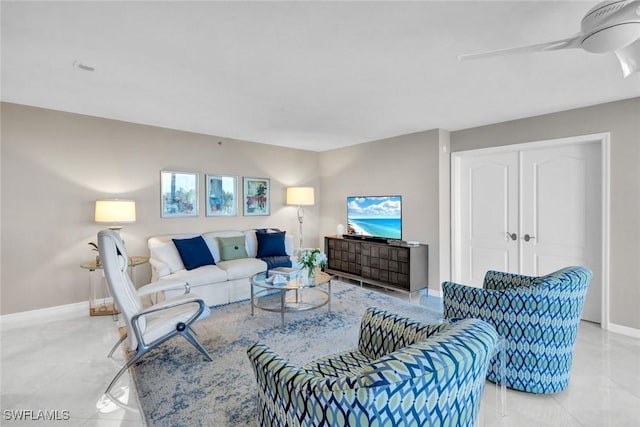 living room featuring light tile patterned floors, baseboards, and a ceiling fan