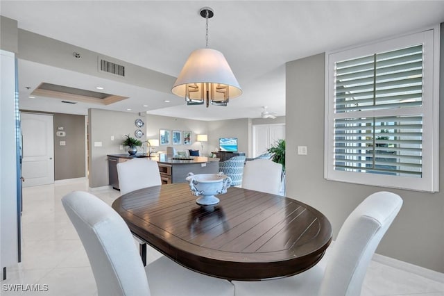 dining area with visible vents, baseboards, light tile patterned floors, recessed lighting, and a raised ceiling