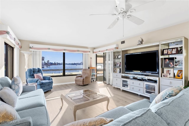 living room with wood finished floors, visible vents, and ceiling fan