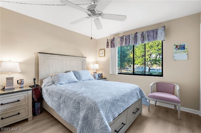 bedroom featuring light wood-type flooring, baseboards, and ceiling fan